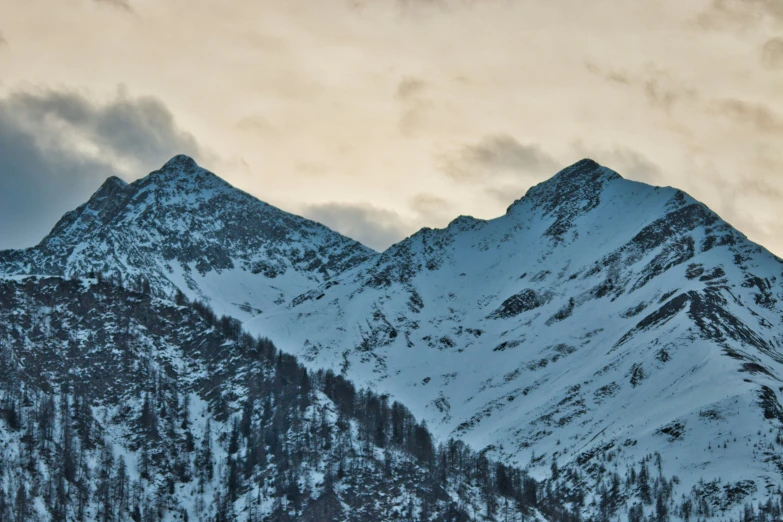 mountain and clouds at night with snow capped peaks