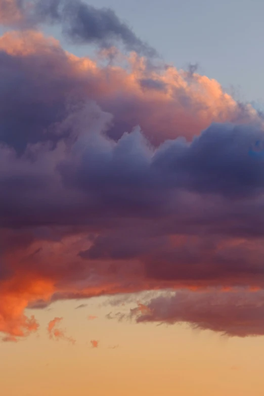 airplane flying across orange and purple cloudy sky