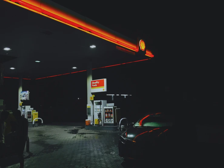 the gas station is filled with gas in a dark parking lot