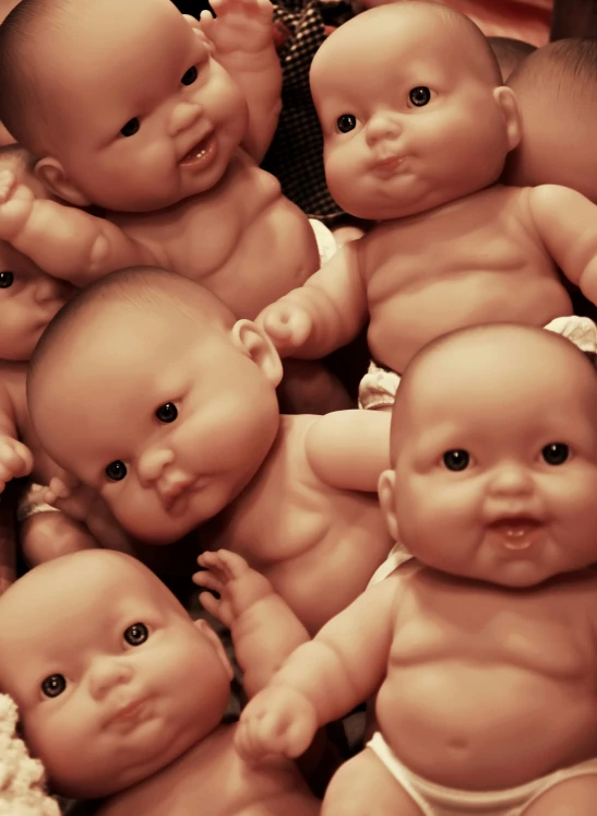 many baby dolls are laying together with one being thrown into the air