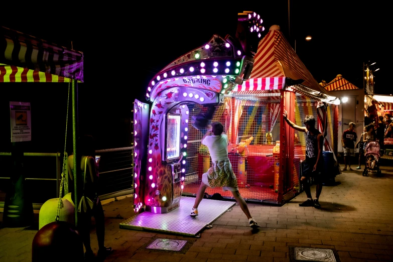 a carnival area with a woman and various brightly colored booths