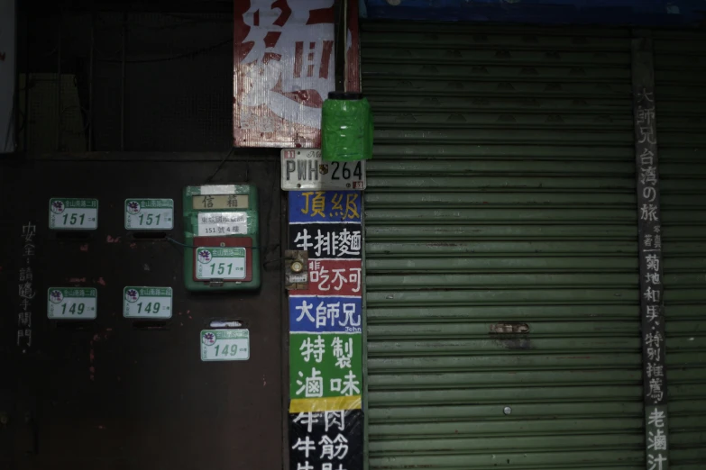 a wall covered with green shutters and various signs