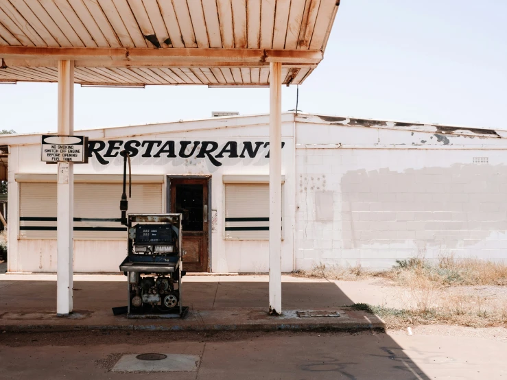 a small white building has a sign and chair on it