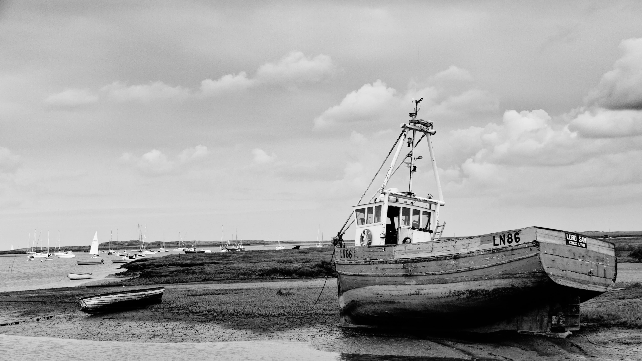 a boat sits on the sand in front of boats