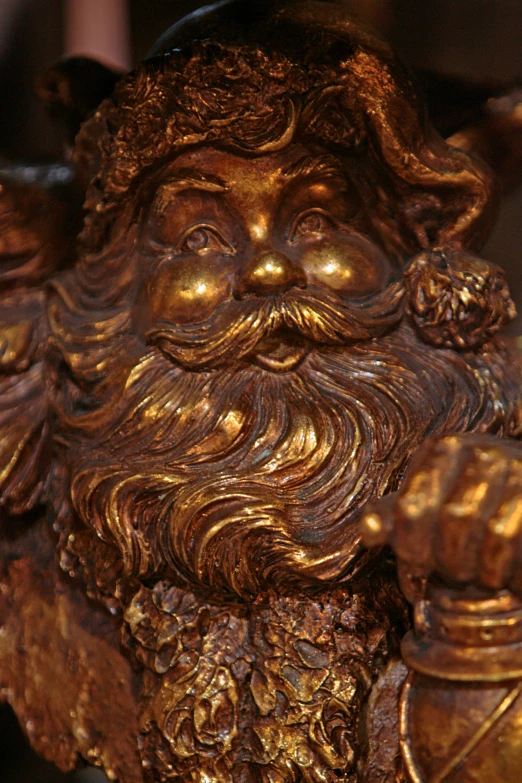 a golden statue of an oriental male with a beard