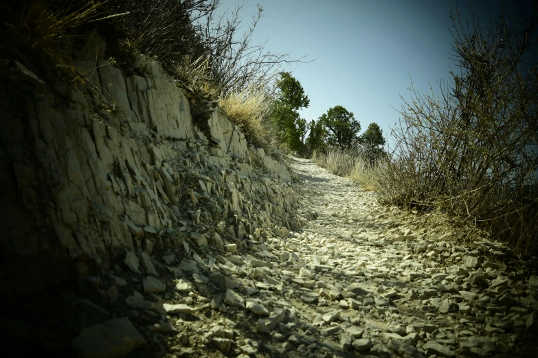 a path is shown uphill by rocks and treeline