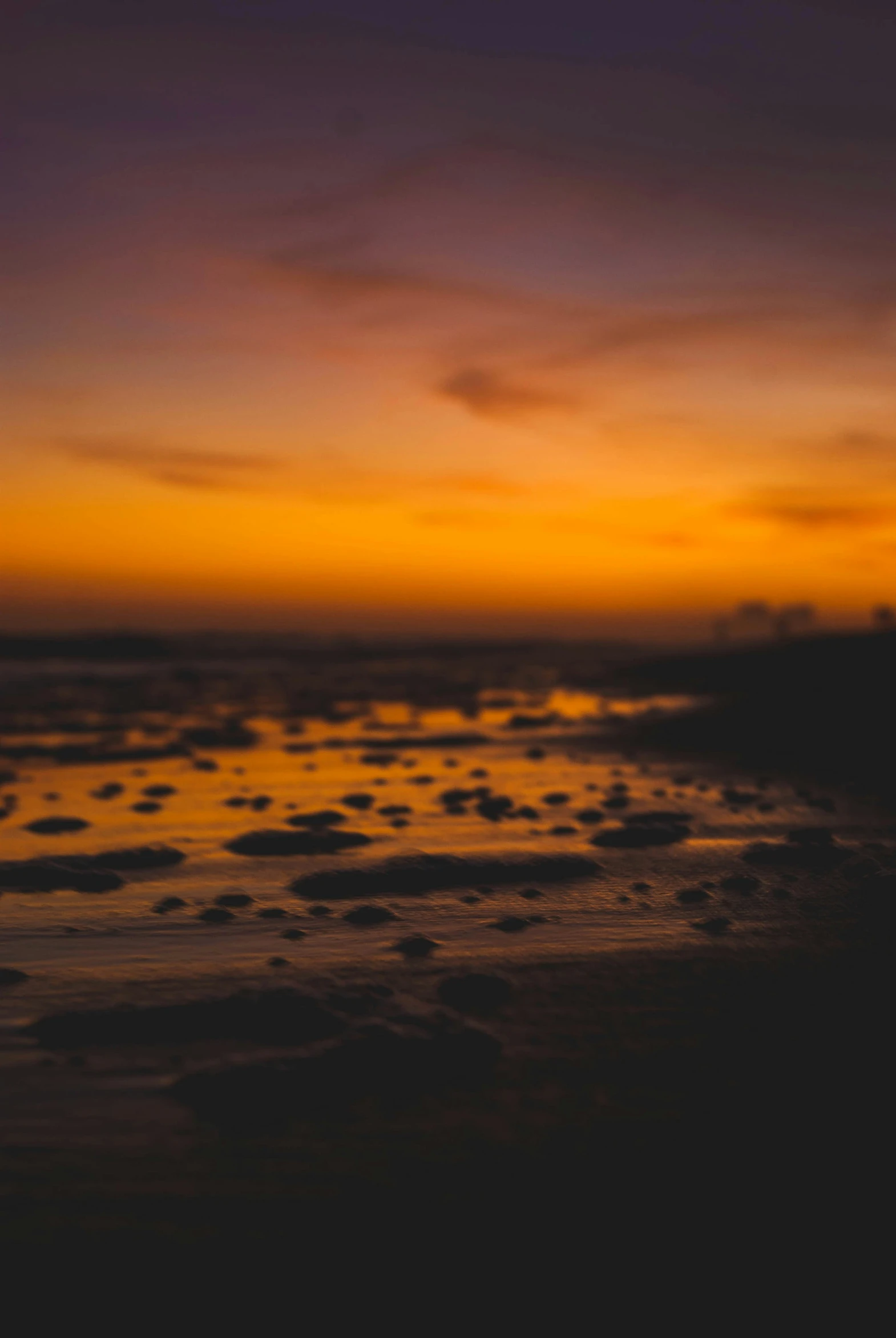 an orange and black cloudy sky at the beach