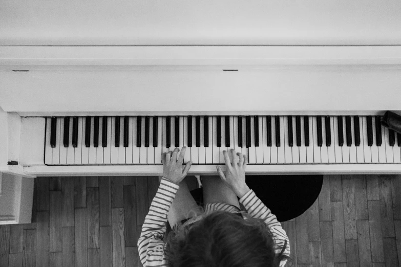 black and white po of a girl playing piano