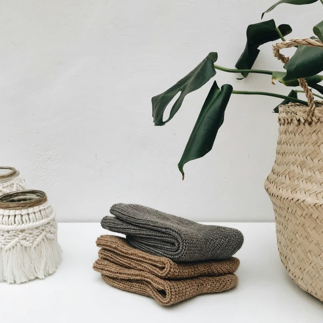 towels sitting next to a woven basket and plant