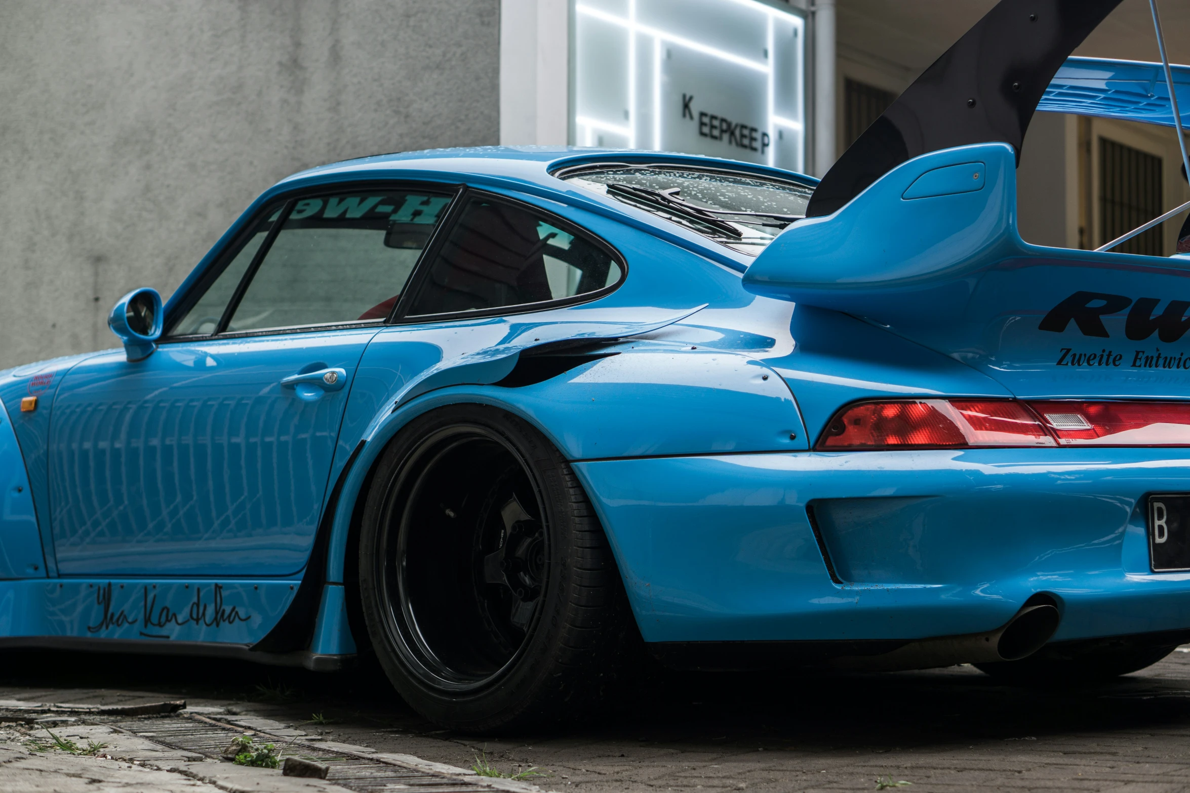 the rear view of a blue sports car