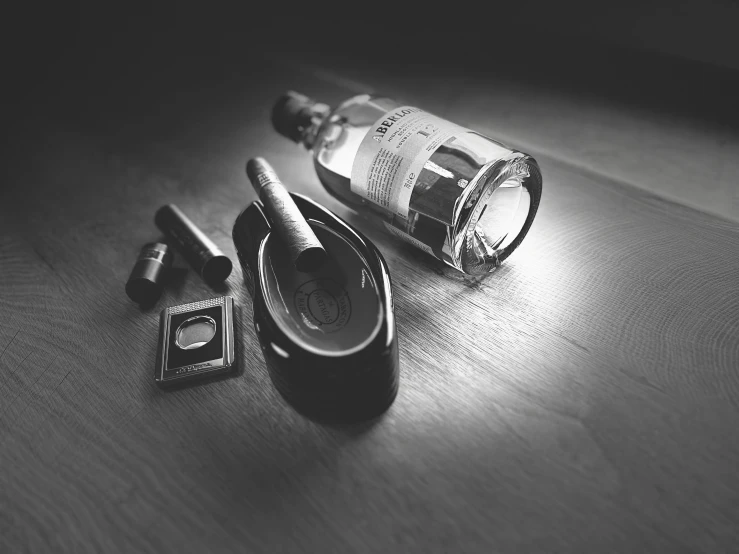 a bottle, comb and razor sitting on a desk