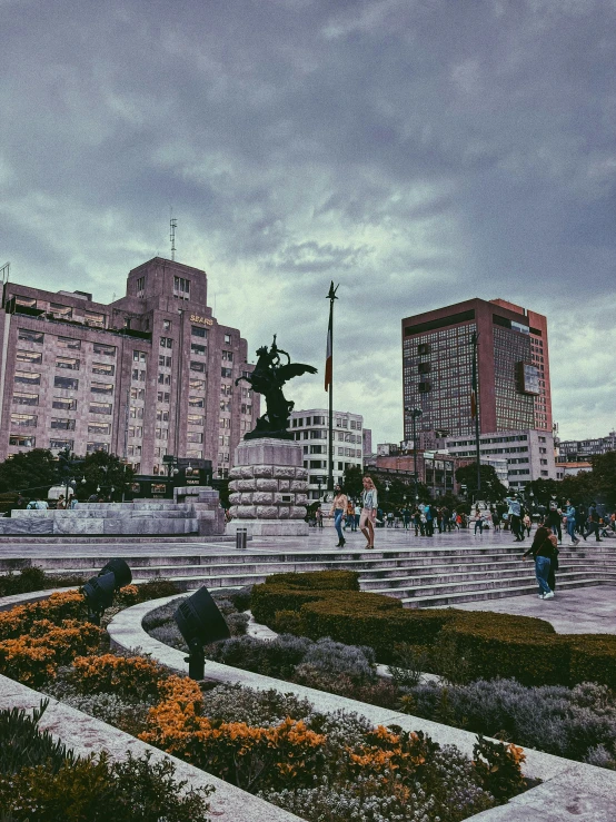 many people are walking around a city square