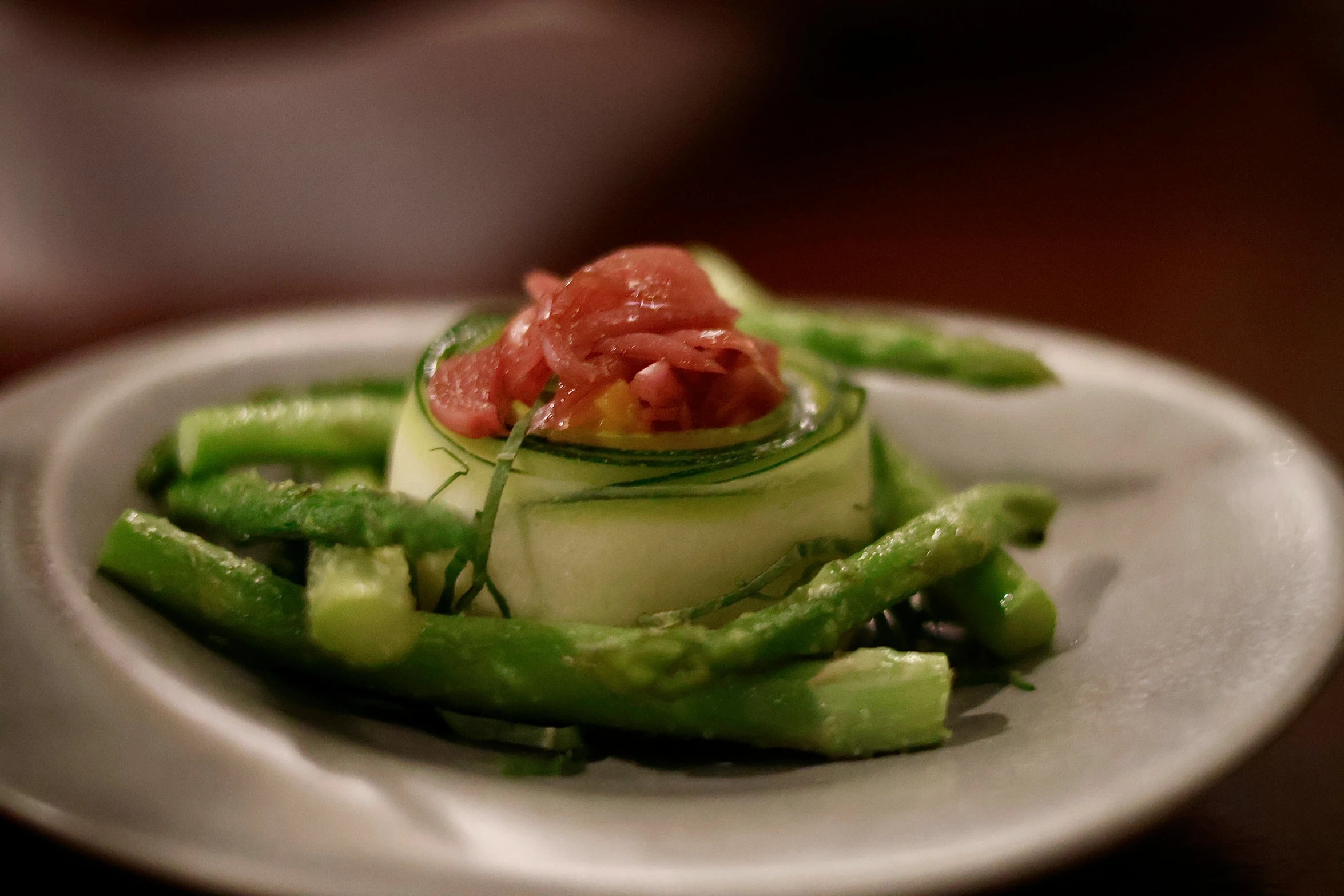 some green asparagus with a few toppings on a plate