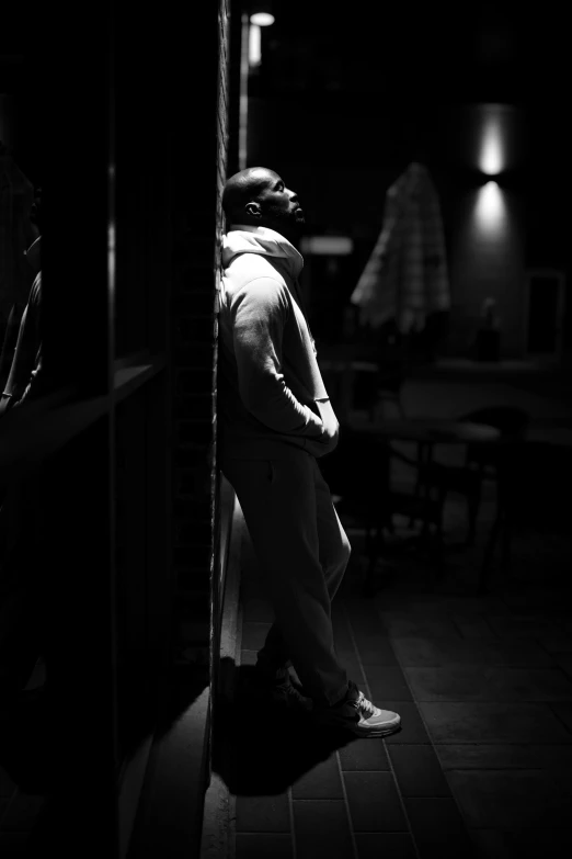 black and white pograph of a person standing in front of a wall