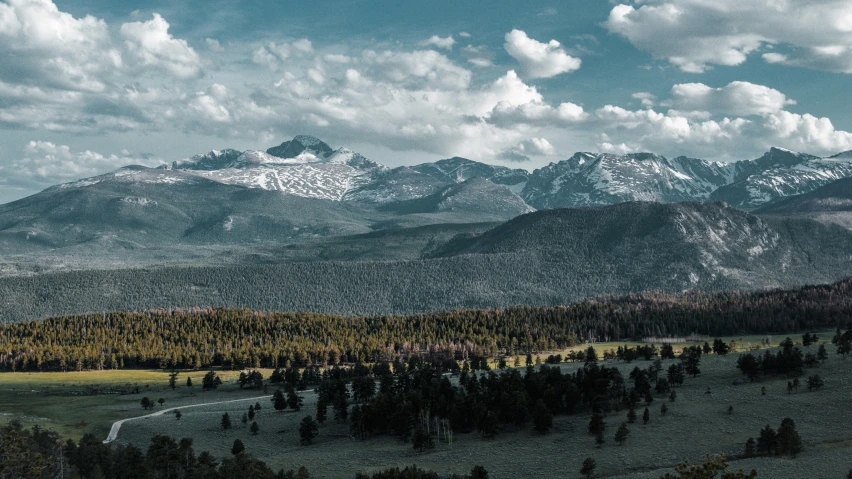 the mountains are covered in trees as well as clouds