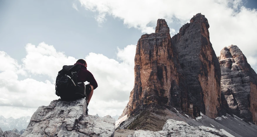 a person sits on a mountain top looking at the sky