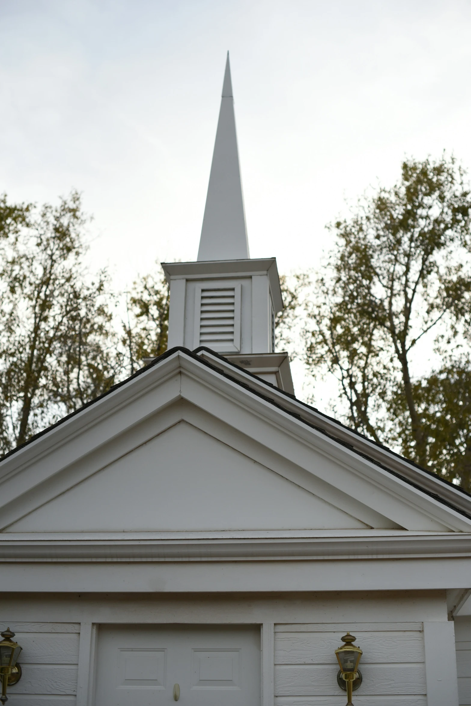 a white building with a tall steeple and door