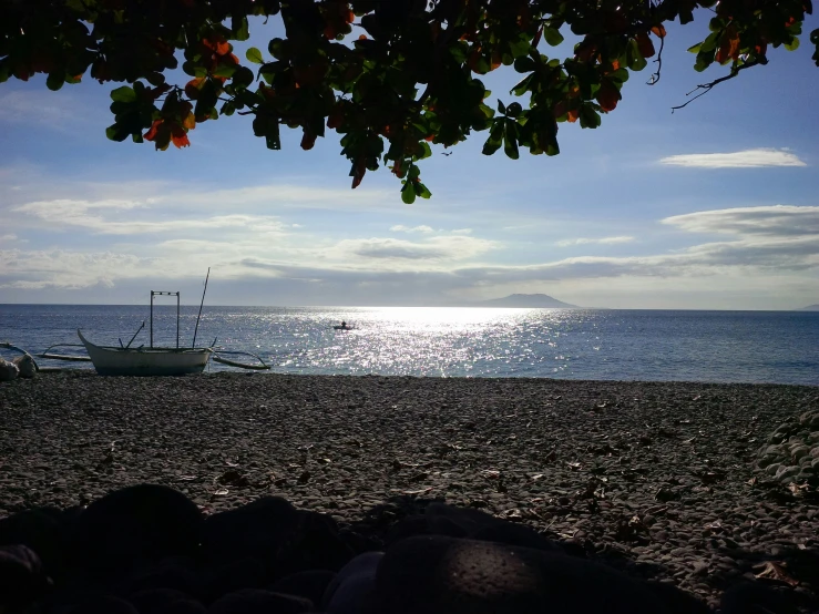 a beach with a boat sitting in the water