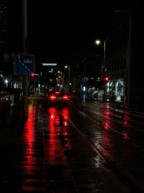 cars drive down the wet road on a rainy night