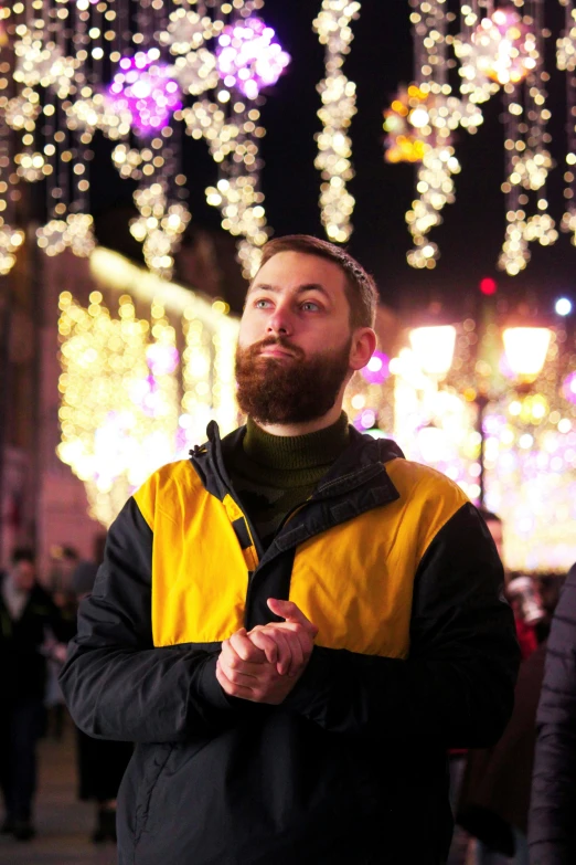 a man looking up at christmas lights in the distance