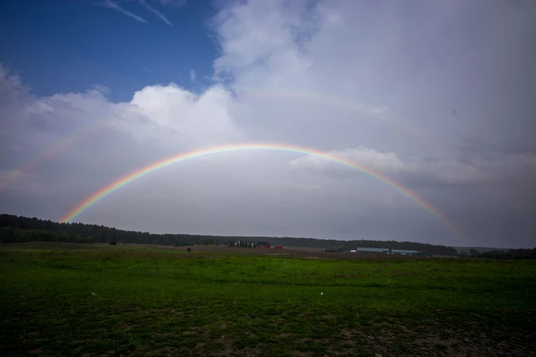 double rainbow in the sky over grassy field