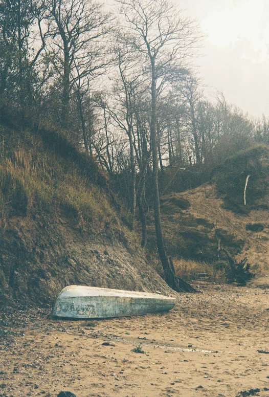 a lone ice boat is floating on the bank of a small lake