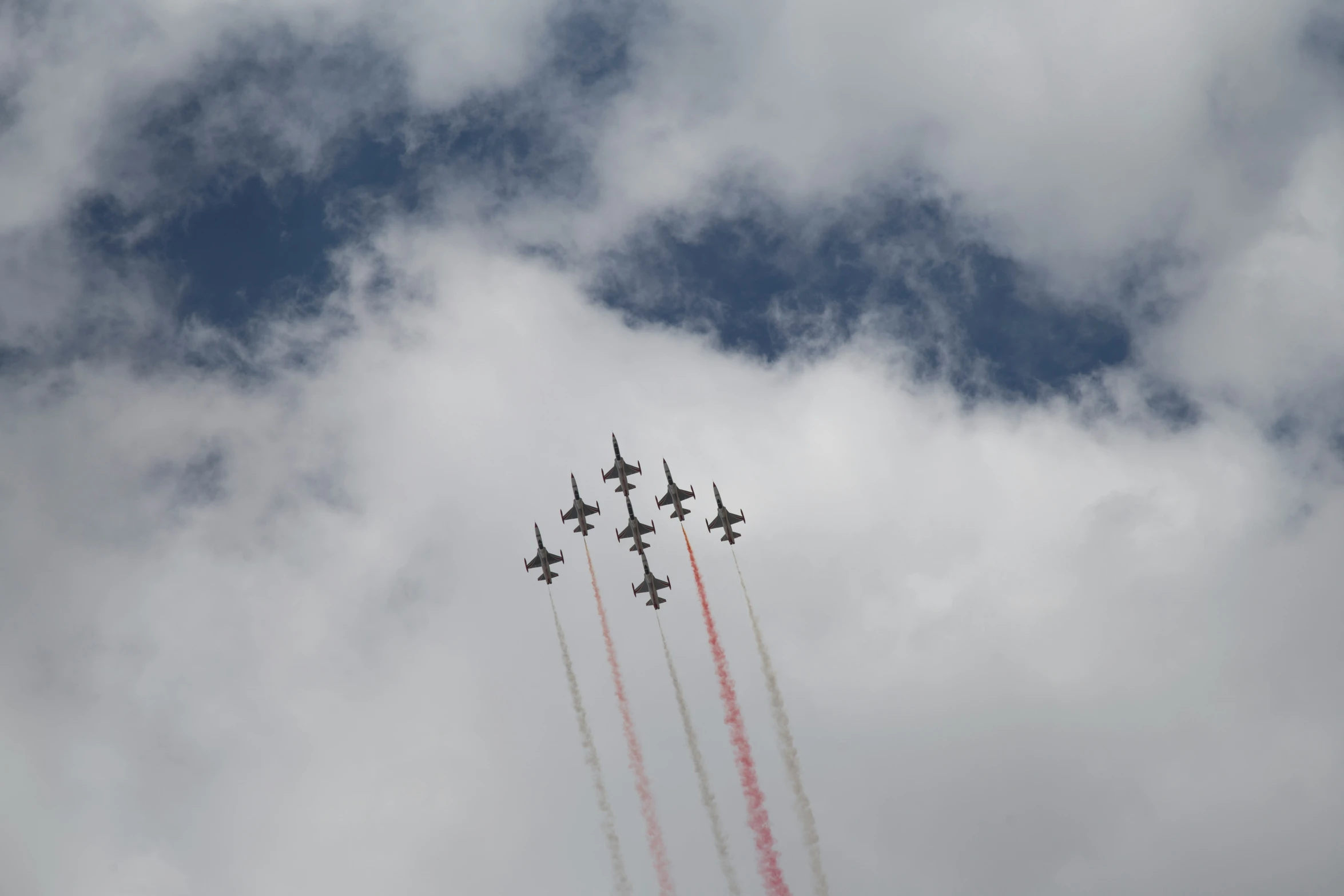 a number of airplanes flying through a cloudy sky