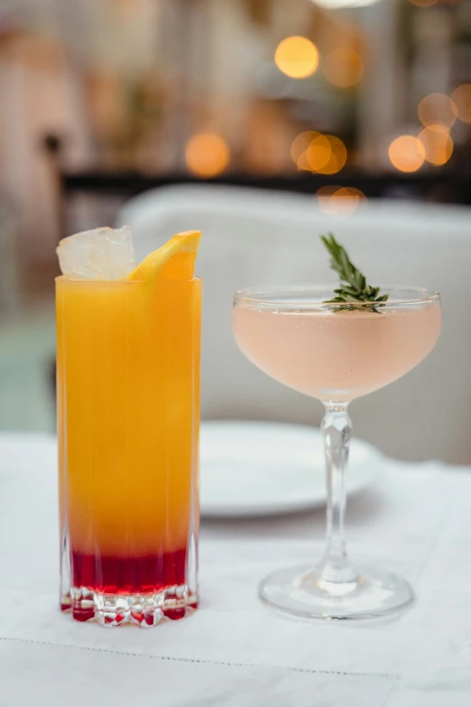 two glasses with different types of drinks on top of a table