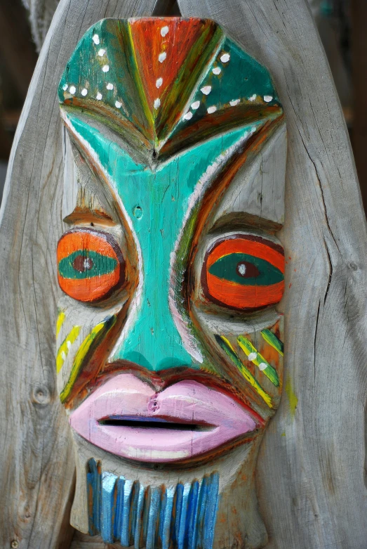 a carved figure sitting on top of a wooden fence