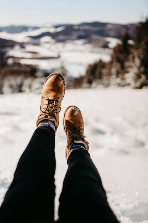 the feet of someone standing in a snowy field