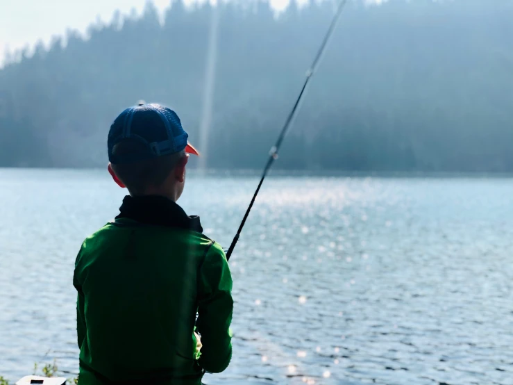 a  fishing at a lake near a forest