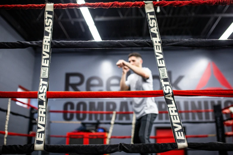 a young man in a white shirt is next to ropes