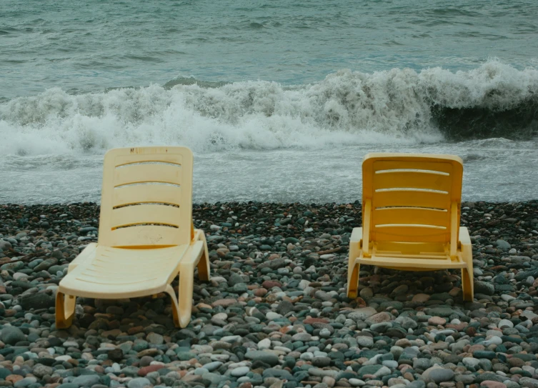 two yellow chairs sit next to the shore