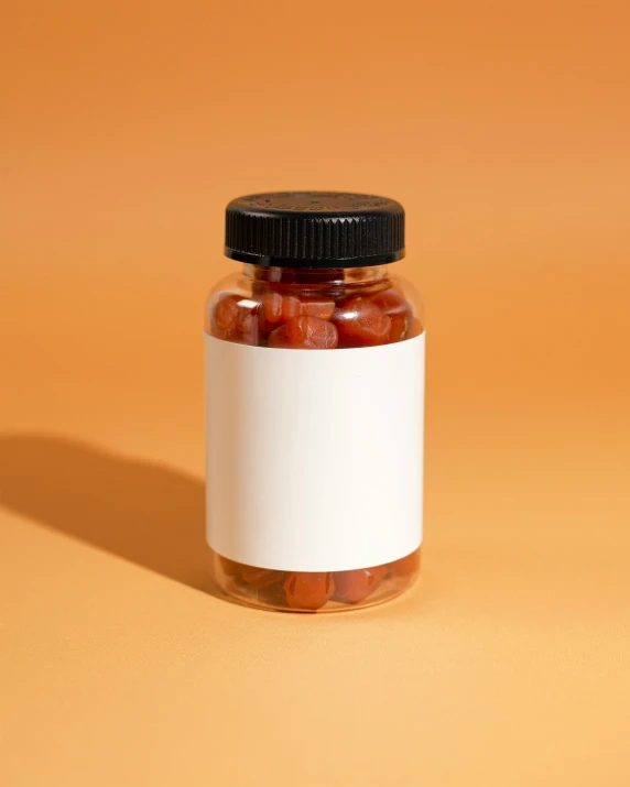 a jar full of gs sits on an orange background