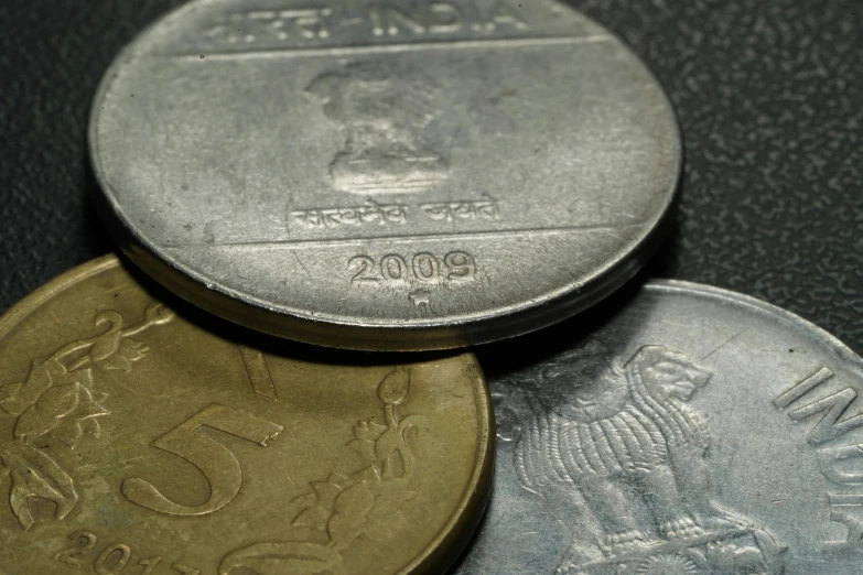 three different sized coins are sitting on the table