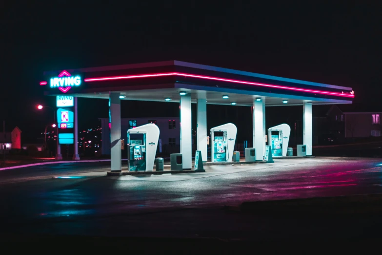 gas station lit up at night with red and blue neons