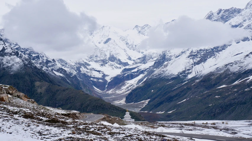 two mountains are snow covered in the middle of a valley