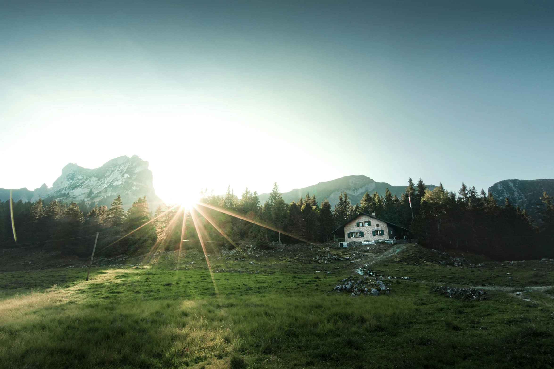 a white house in the middle of a large meadow