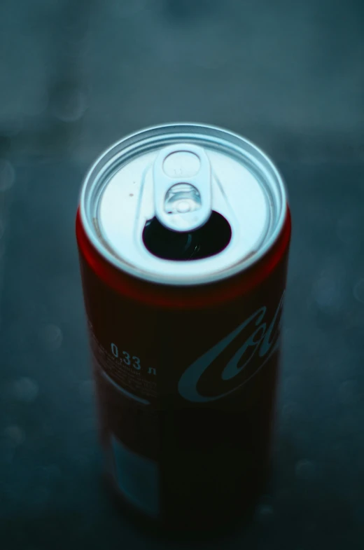 a soda can with the lid up and a lit candle in the middle
