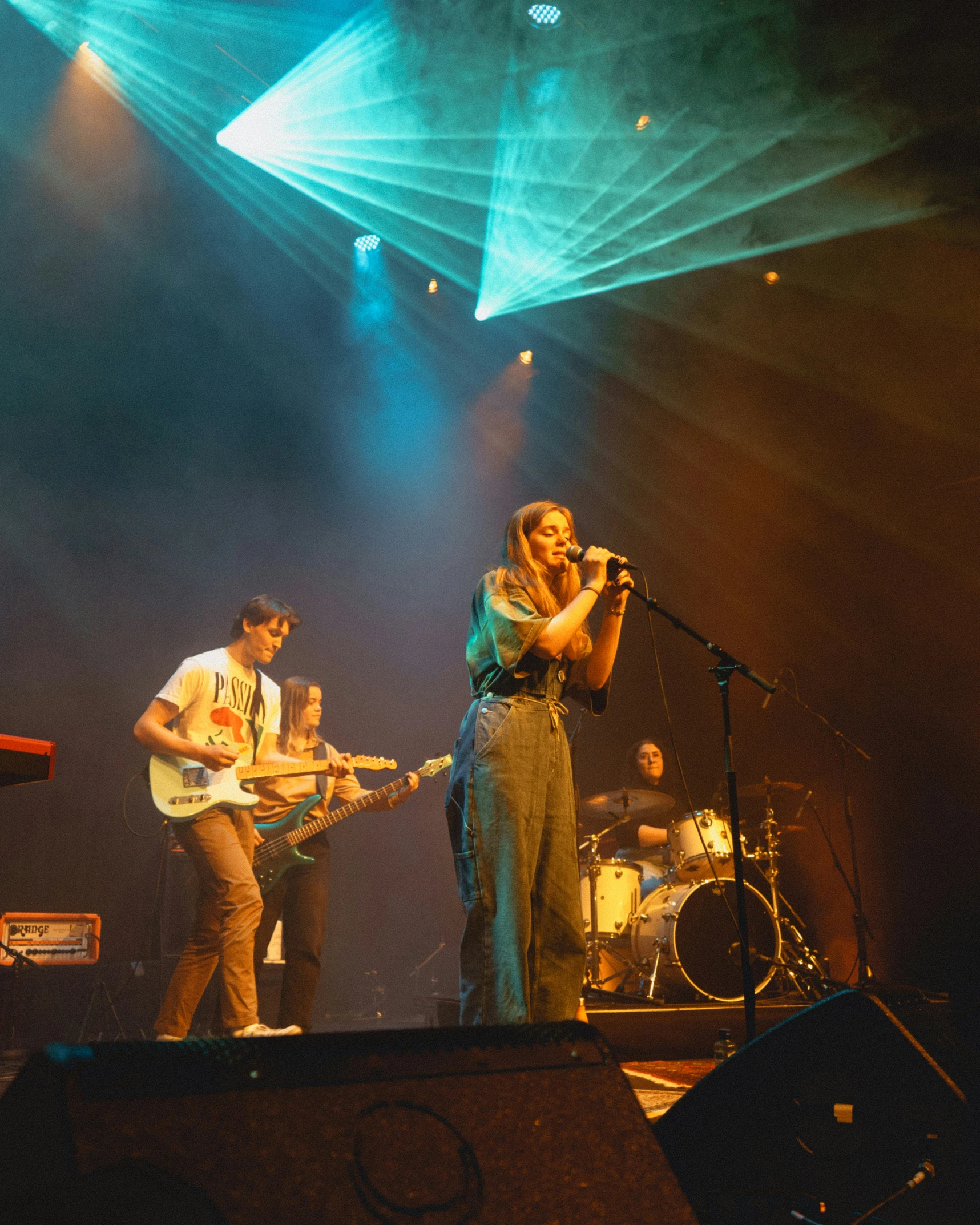 band members singing and playing guitar on stage