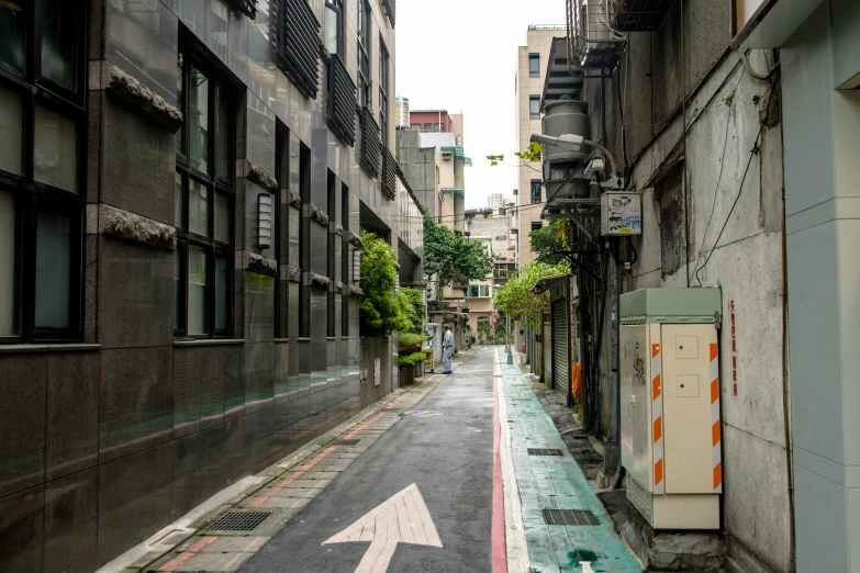 narrow street in a large city next to building with windows