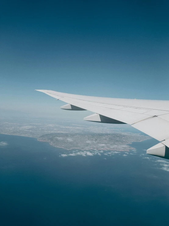 airplane wing on clear day with water below