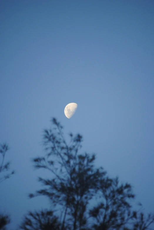 the moon is in the distance against the blue sky