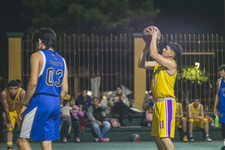 a person with a basketball wearing a yellow and blue uniform