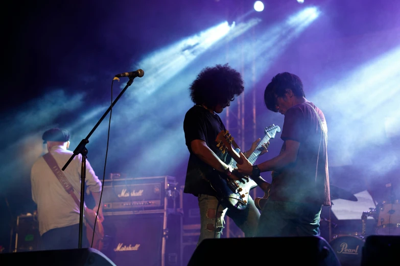 two people are on stage with guitars