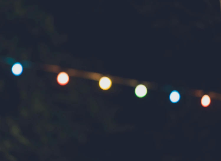 a string of colored lights on a fence