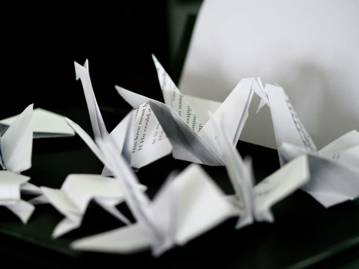 paper cranes on a table next to a computer