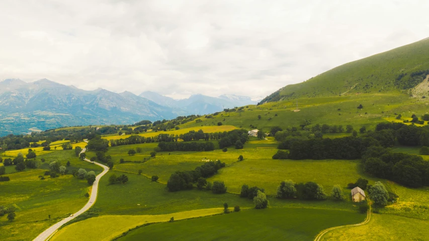 green hills that have a winding road going through them