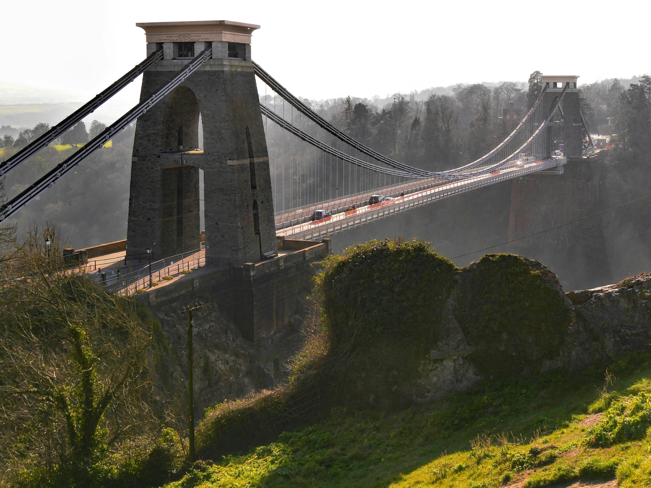 a long bridge spans across a green hilly area