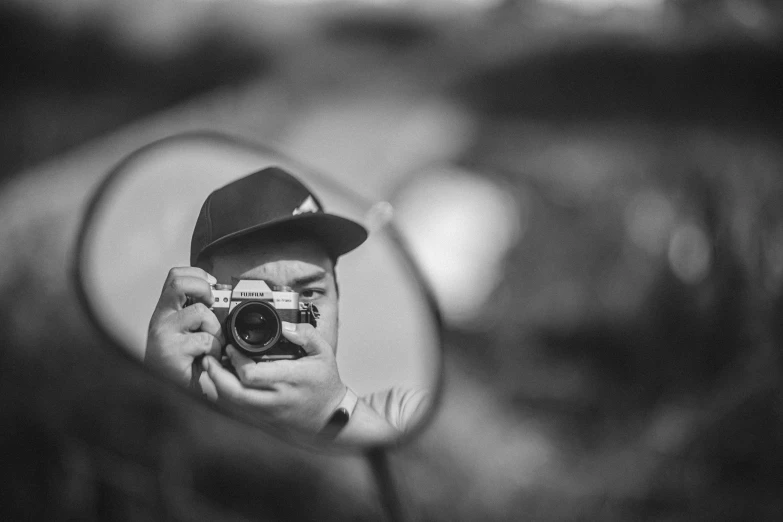 man holding camera up to mirror with other person taking a selfie